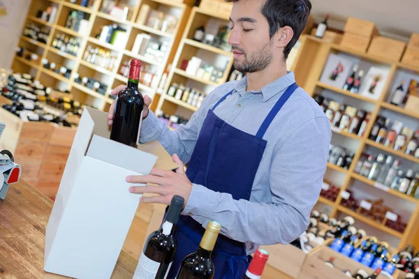 Felice giovane venditore indossare uniforme in casa del vino — Foto Stock
