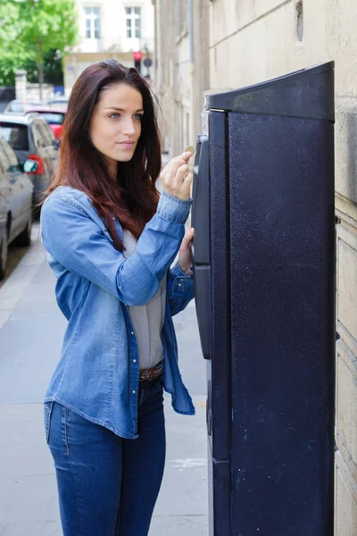 Bela jovem mulher pagando por estacionamento — Fotografia de Stock