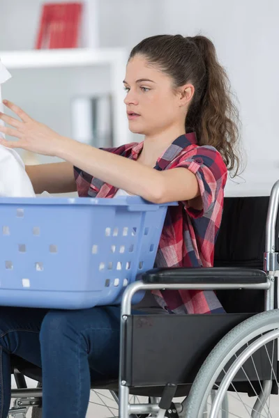 Vrouw in rolstoel doen van Wasserij — Stockfoto