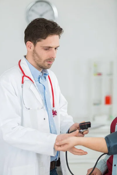 Médico sénior a tomar o batimento cardíaco do seu paciente — Fotografia de Stock