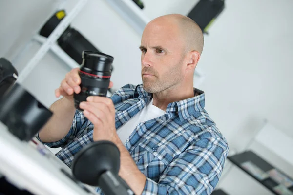 Reparateur holding cameralens — Stockfoto