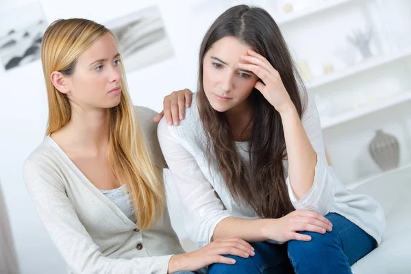 Donna confortante piangendo amico sul divano in casa — Foto Stock