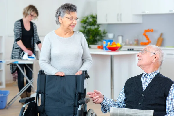 Äldre par hemma med vårdare att hjälpa till — Stockfoto