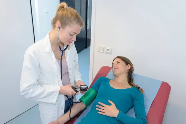 Doktor měření krevního tlaku těhotné ženy — Stock fotografie