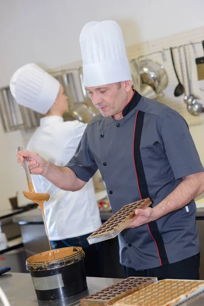 Chef corte de chocolate caseiro na cozinha — Fotografia de Stock