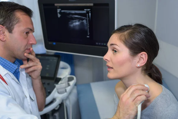 Ο γιατρός χρησιμοποιεί ένα μηχάνημα υπερήχων στο λαιμό γυναίκες ασθενείς — Φωτογραφία Αρχείου