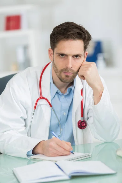 Médico olhando sério em seu escritório — Fotografia de Stock