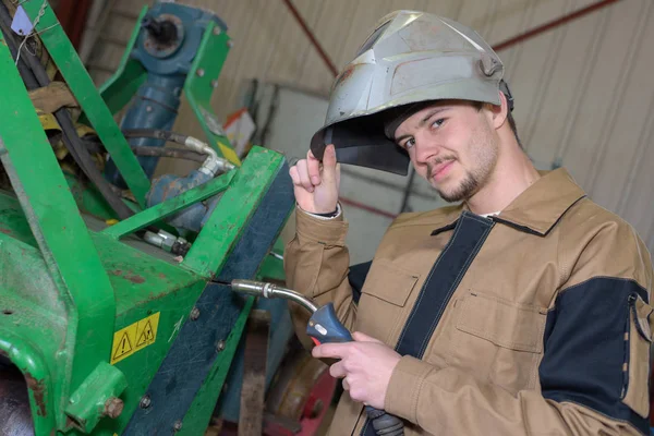 在工厂里干活的快乐学徒焊工 — 图库照片