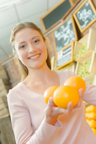 Donna che sceglie alcune arance al supermercato — Foto Stock