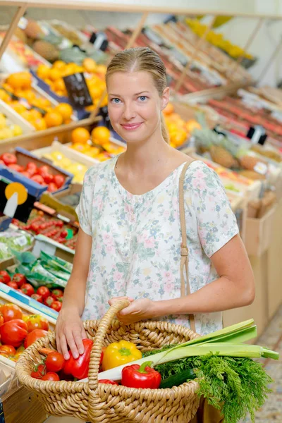 Junge Frau kauft Gemüse ein — Stockfoto