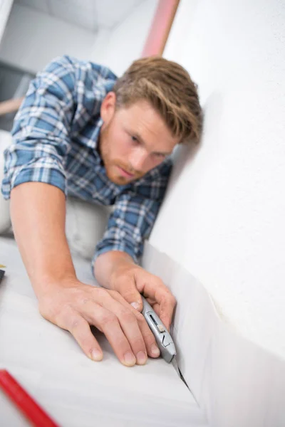 Unga stiliga handyman installation mattan med fräs — Stockfoto