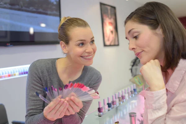 Mulher escolhe a cor do polonês para manicure — Fotografia de Stock