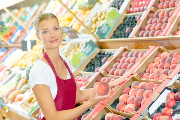 Egy nő dolgozik egy gyümölcsös standon. — Stock Fotó