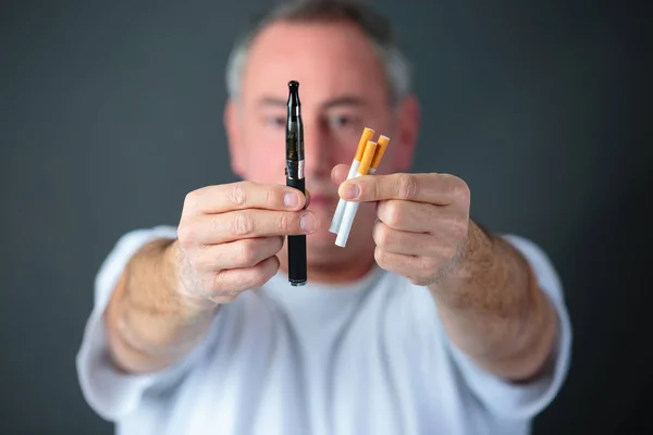 Médecin comparant cigarettes de tabac conventionnelles et vaporisateur électronique — Photo