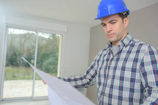 Homme dans la maison regardant les plans — Photo