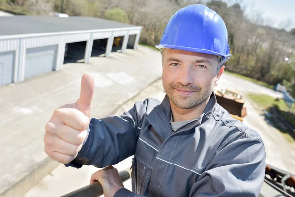 Joyful manliga byggnadsarbetare som står på en kran — Stockfoto