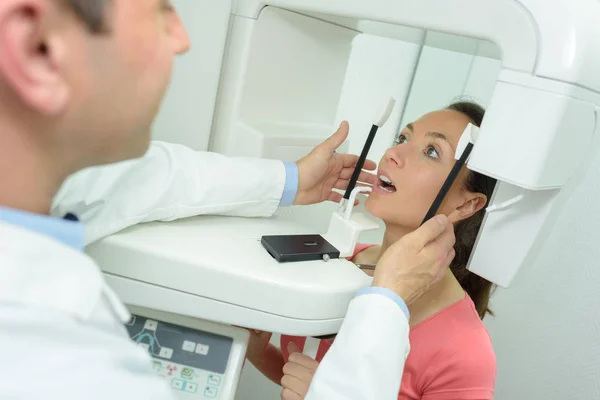 Стоматолог-постановщик рентгеновского аппарата в стоматологической клинике — стоковое фото
