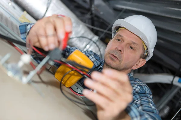 Hombre haciendo montaje para cables eléctricos en el techo —  Fotos de Stock
