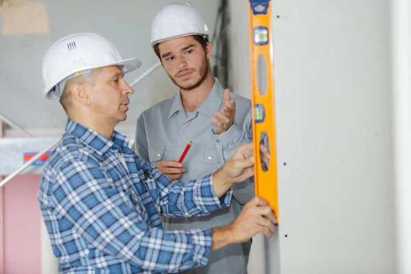 Électricien avec apprenti travaillant dans une nouvelle maison — Photo