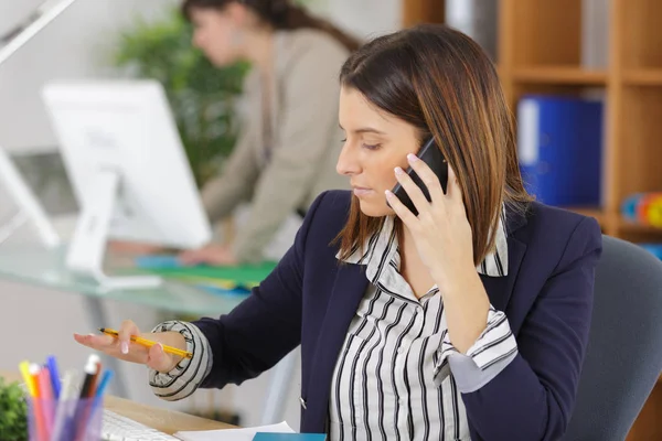 Vrouwelijke beambte, na een gesprek op de telefoon — Stockfoto