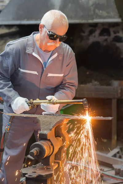 Senior-Arbeiter arbeitet mit Schleifer produziert Blitz Funkeln — Stockfoto