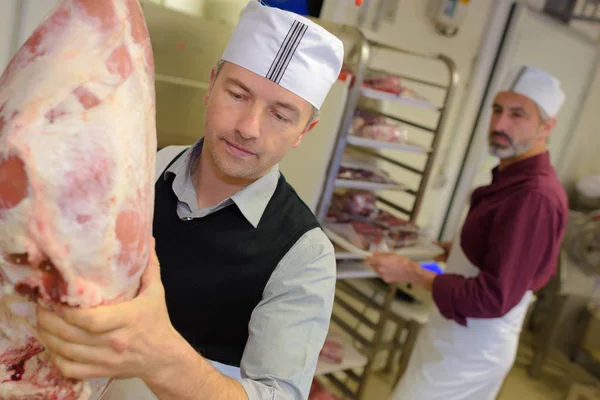 Carnicero maduro trabajando en la carnicería —  Fotos de Stock