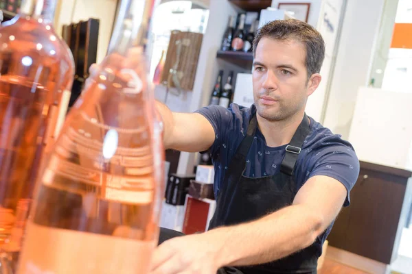 Vendedor instalar botellas en su tienda —  Fotos de Stock