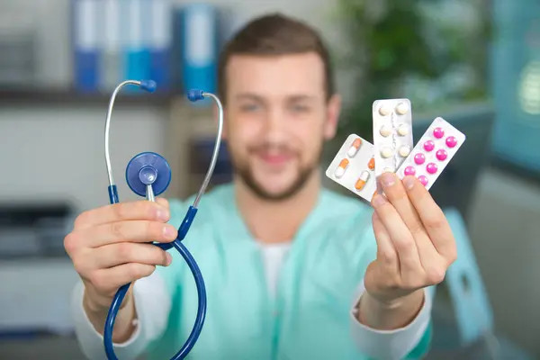 Junge Ärztin zeigt Pillen — Stockfoto