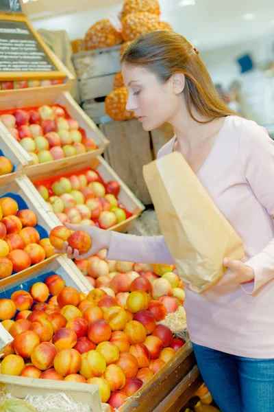 Wprowadzenie owoców do papierowej torebki w supermarkecie — Zdjęcie stockowe