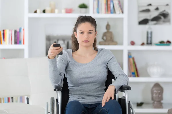 Mulher deficiente em cadeira de rodas assistindo filmes em casa — Fotografia de Stock