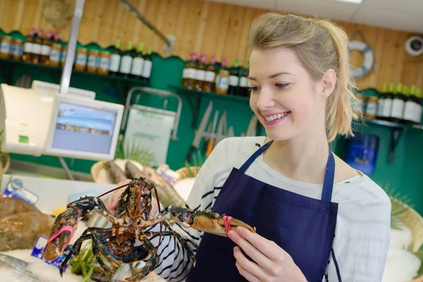 Female working holding a lobster in a fish supermarket — Stock Photo, Image