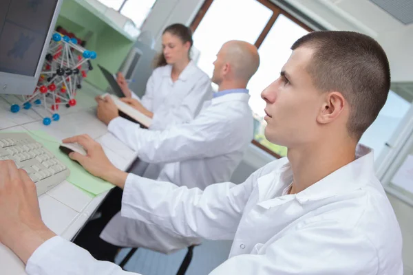 在医学实验室工作的年轻人使用计算机 — 图库照片