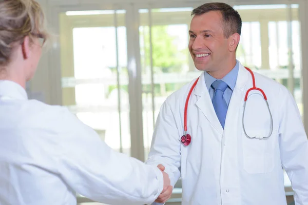 Doctor estrechando la mano con la mujer — Foto de Stock