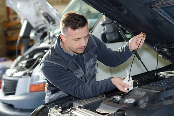 Automechaniker ersetzt Öl am Motor in Garage — Stockfoto