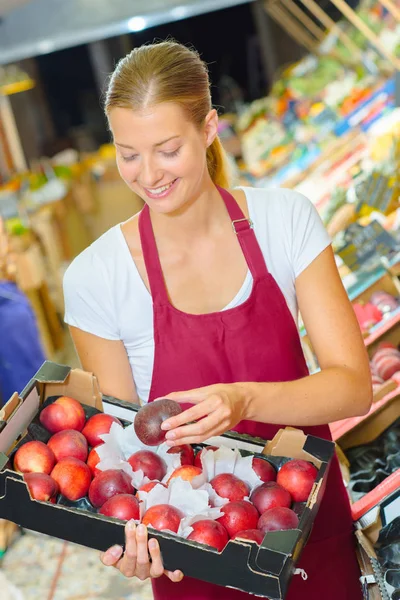 Salesgirl in supermarket and young — Stock Photo, Image