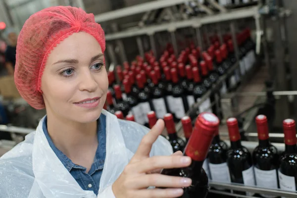 Werkneemster met behulp van de machine aan het werk in wijn fabriek — Stockfoto