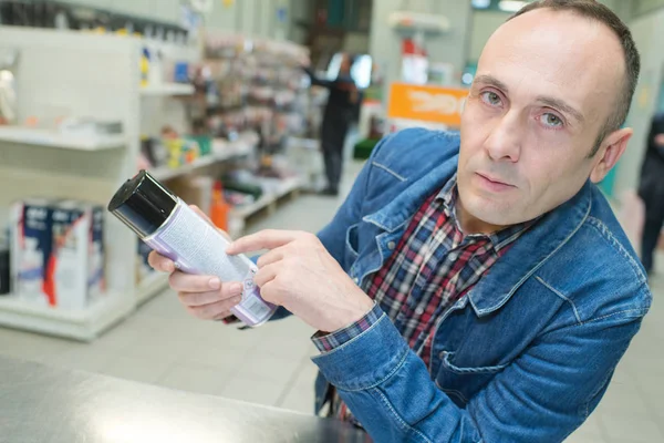 Homem escolhendo suplementos de estimação em petshop — Fotografia de Stock