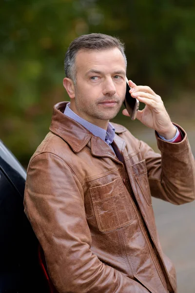 Man använder sin telefon i utomhus park — Stockfoto