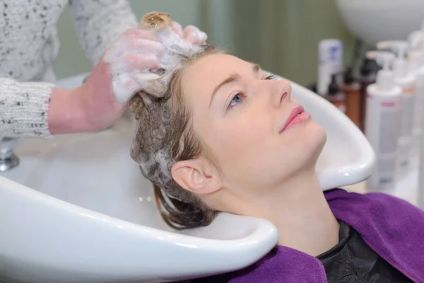Krásná žena dostat hairwash do kadeřnictví — Stock fotografie