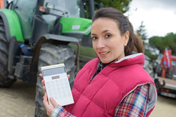 Portréja egy traktor eladó tartja a számológép — Stock Fotó