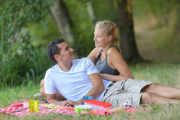 Junges Paar bei einem Picknick an einem sonnigen — Stockfoto