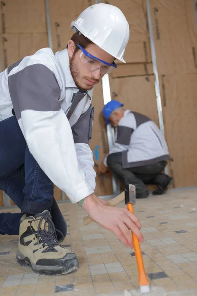 Young tile installer removing the old tiling — Stock Photo, Image