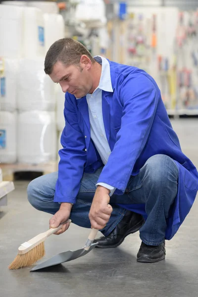 Empleado de ferretería limpiando el piso — Foto de Stock