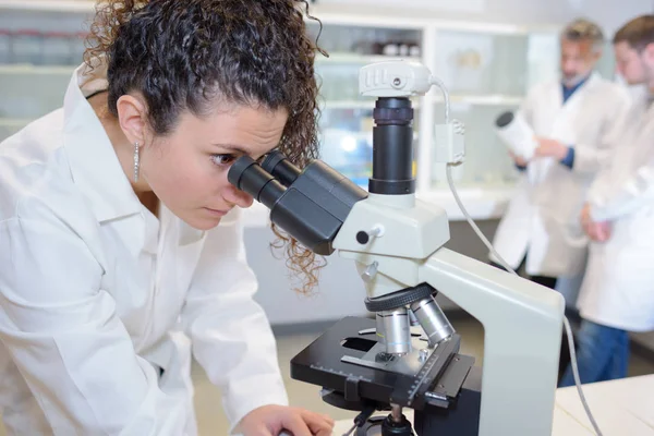 Cientista feminina olhando para o microscópio — Fotografia de Stock