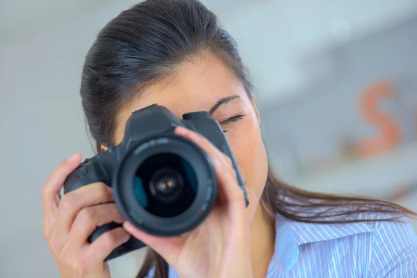 Uma menina tirando uma foto com uma câmera dslr — Fotografia de Stock