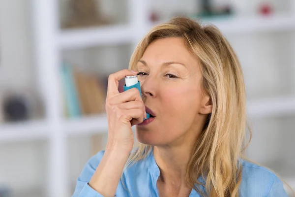 Κοντινό πλάνο γυναίκα τη συσκευή εισπνοής άσθμα χρήση στο σαλόνι- — Φωτογραφία Αρχείου