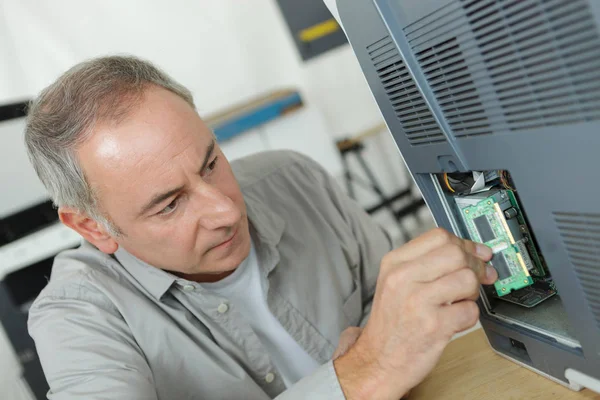 Średnim wieku człowiek ustalania obwodów elektronicznych zbliżenie — Zdjęcie stockowe