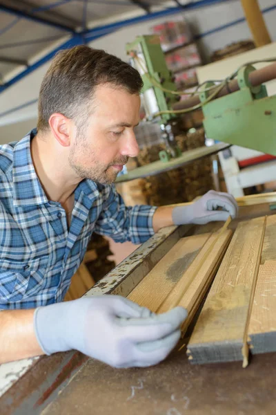 Mitarbeiter eines Sägewerks bei der Arbeit mit Holzwerkzeugen und Maschinen — Stockfoto