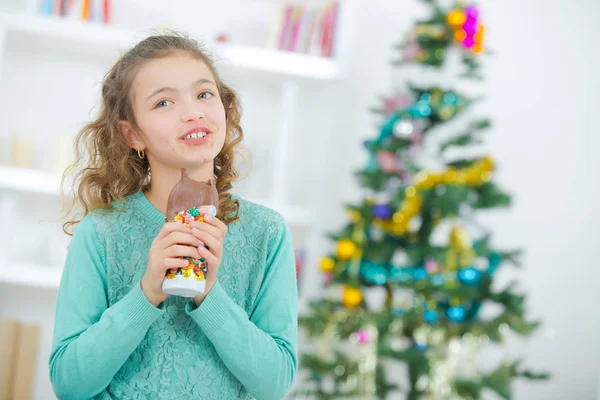 Young girl eating Christmas chocolate — Stock Photo, Image