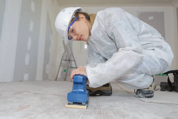 Vrouwelijke bouwer schuren vloer — Stockfoto